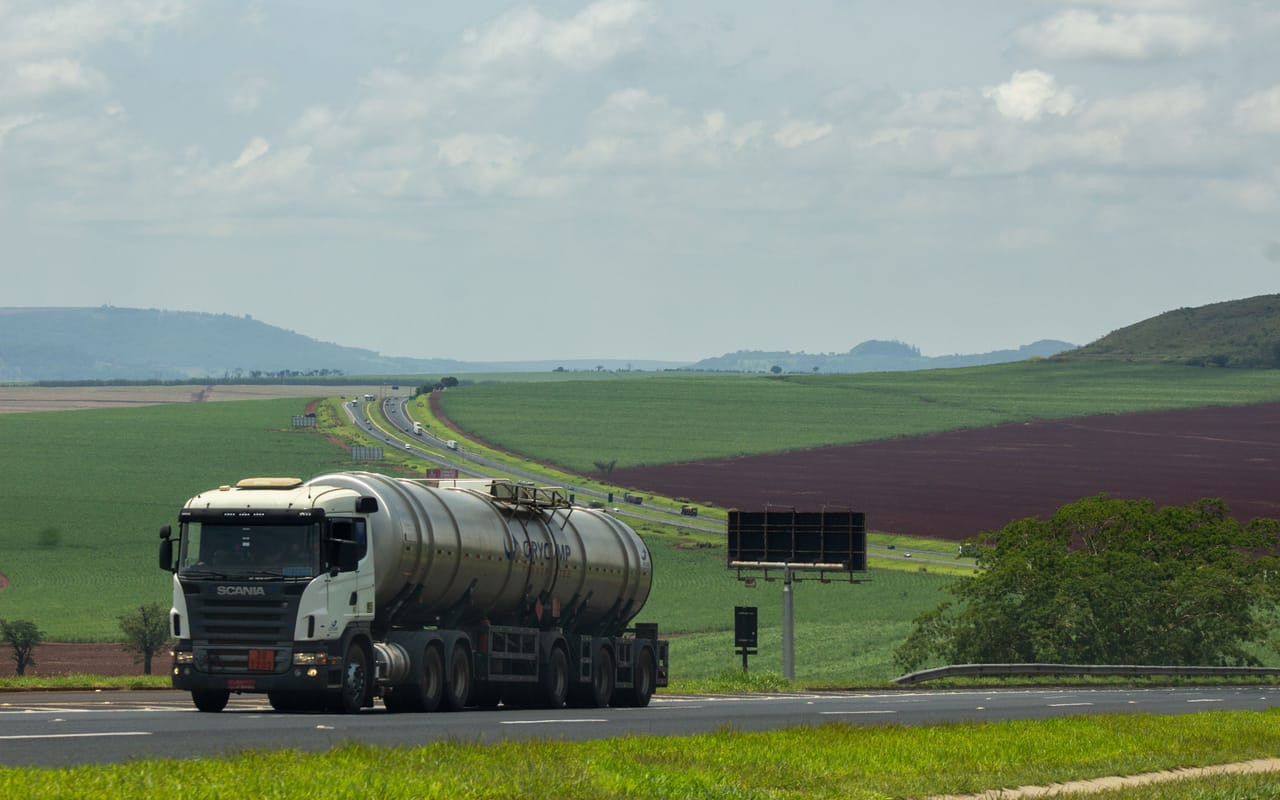 Caminhão-tanque em rodovia entre plantações
