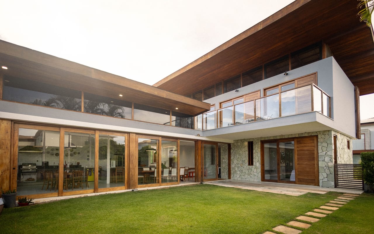 Casa contemporânea de dois andares com jardim e amplas portas de vidro